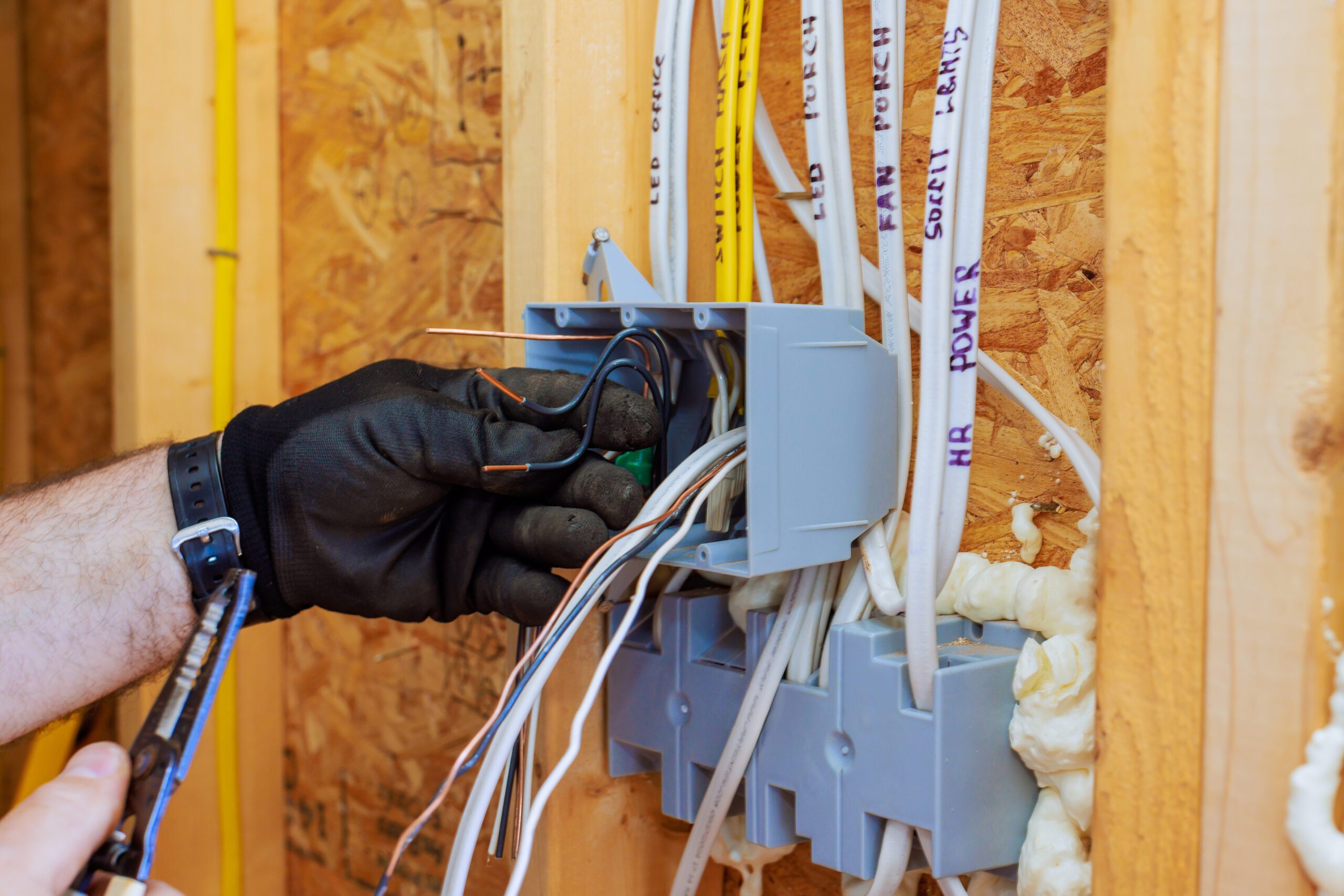 Electrician working on circuit box installation during home renovation project in a residential area